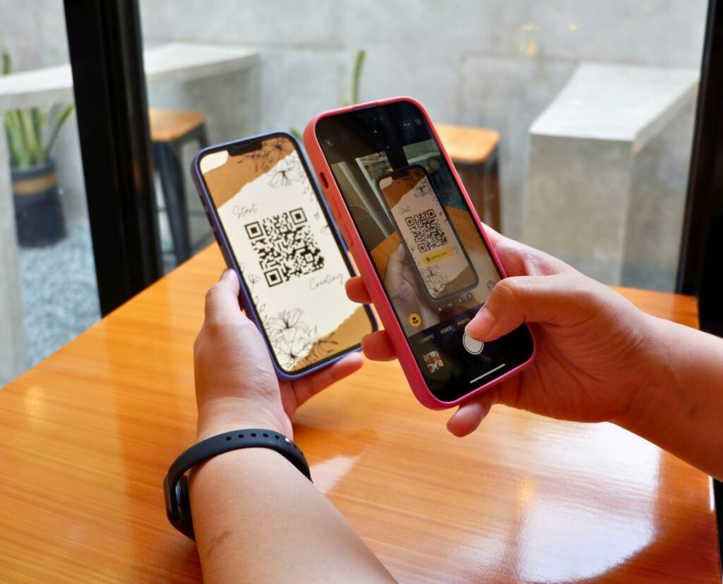 Two hands holding smartphones scanning QR codes.